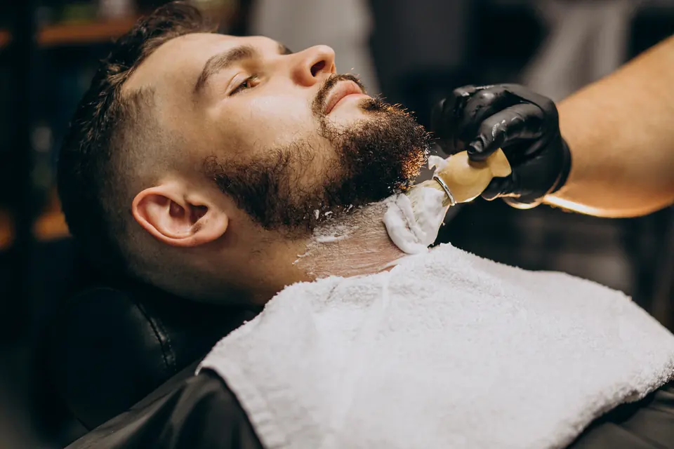 Barba sendo preparada com espuma antes da navalha