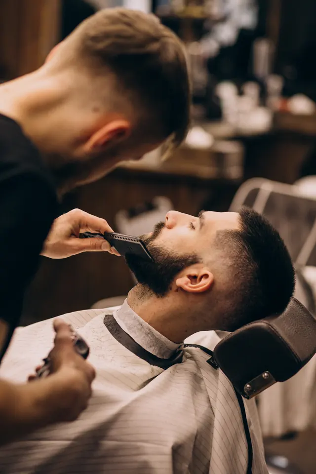 Barbeiro alinhando a barba com pente
