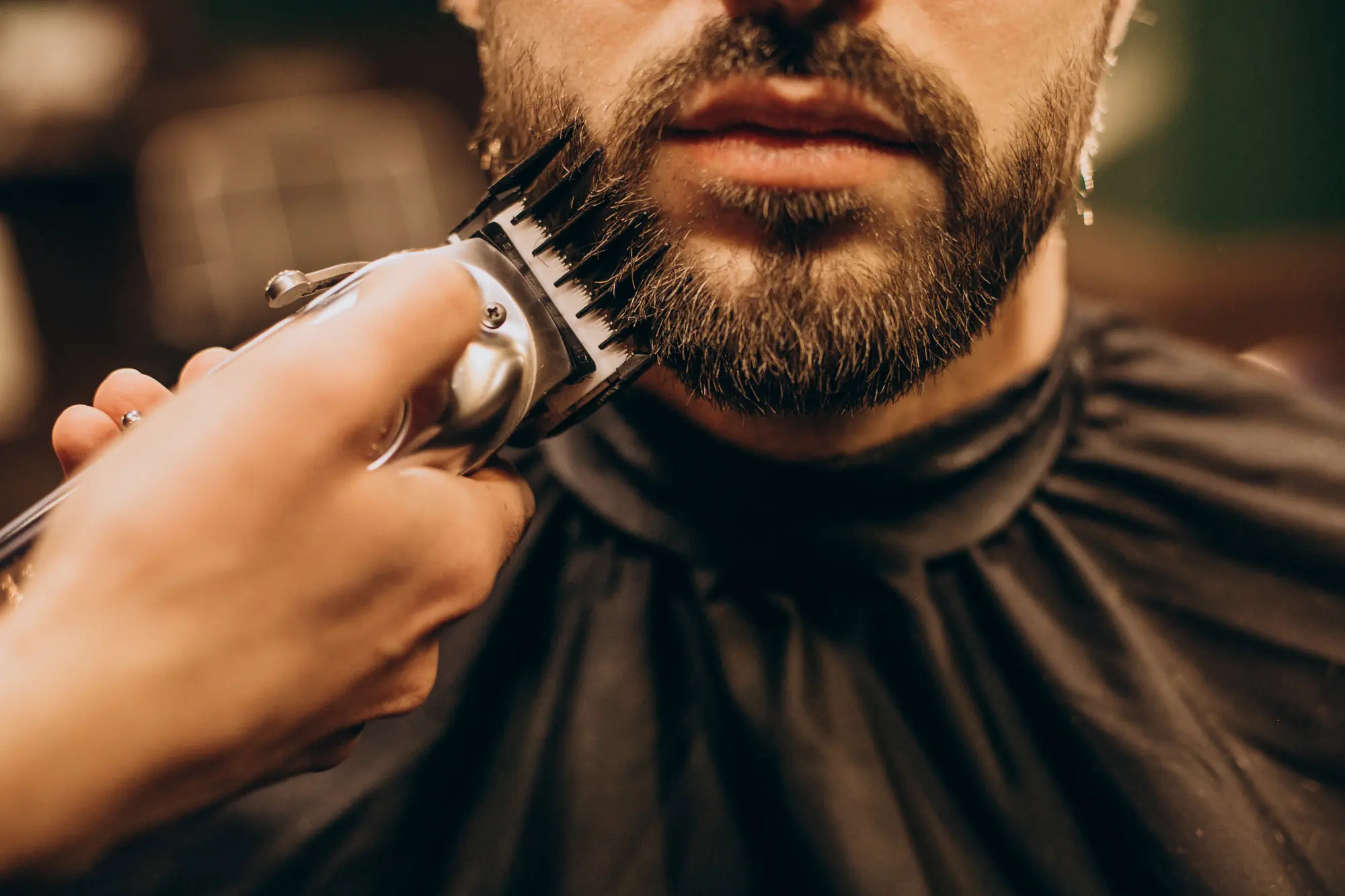 Barbeiro aparando a barba com máquina